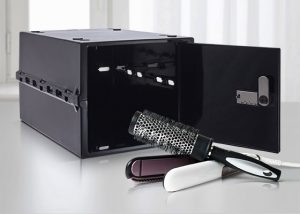 A black lockable box being used to store a hairdressers hairbrush and scissors